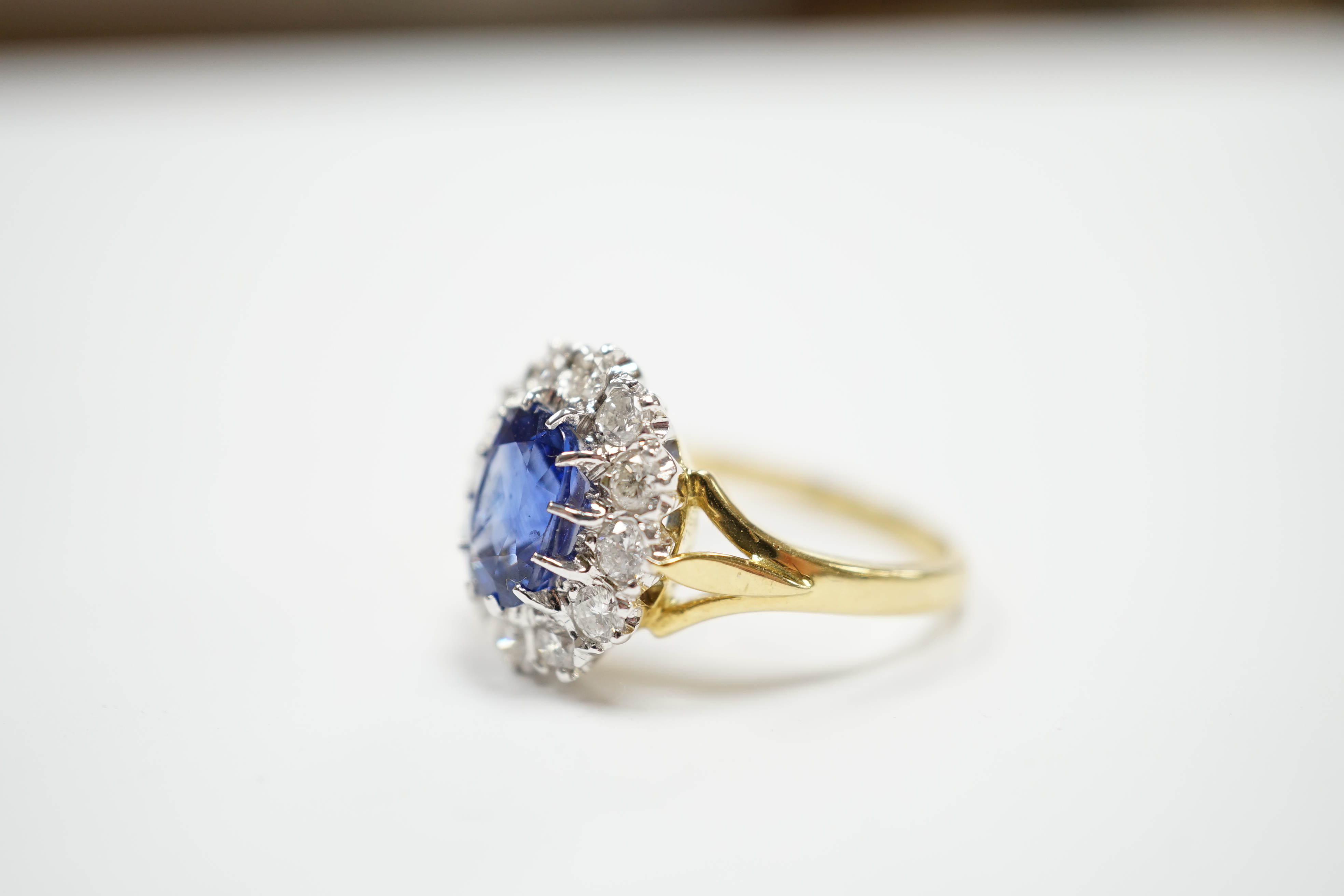 A modern 18ct gold, sapphire and diamond set oval cluster ring, size O, gross weight 5.6 grams.